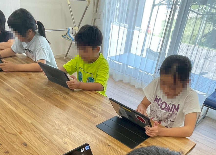  
											真剣な表情で曲作りに打ち込む子どもたち