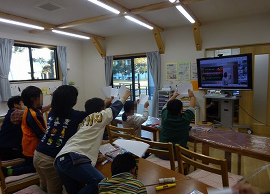  
											答えを書いた紙を元気よく見せる子どもたち