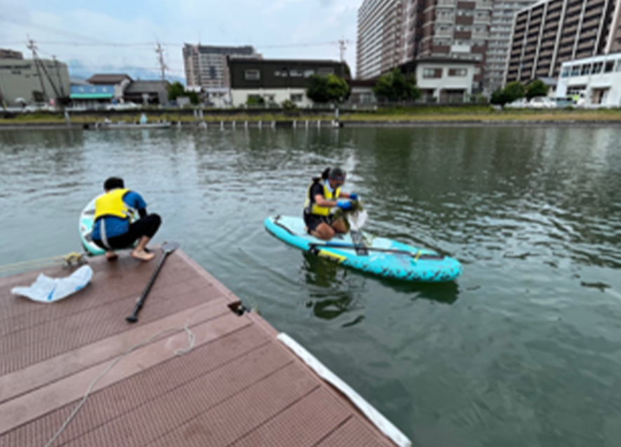 SUPに乗り水上のごみ拾い