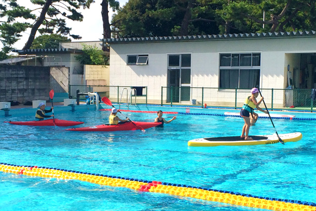 プールでSUPを体験中の子供たち