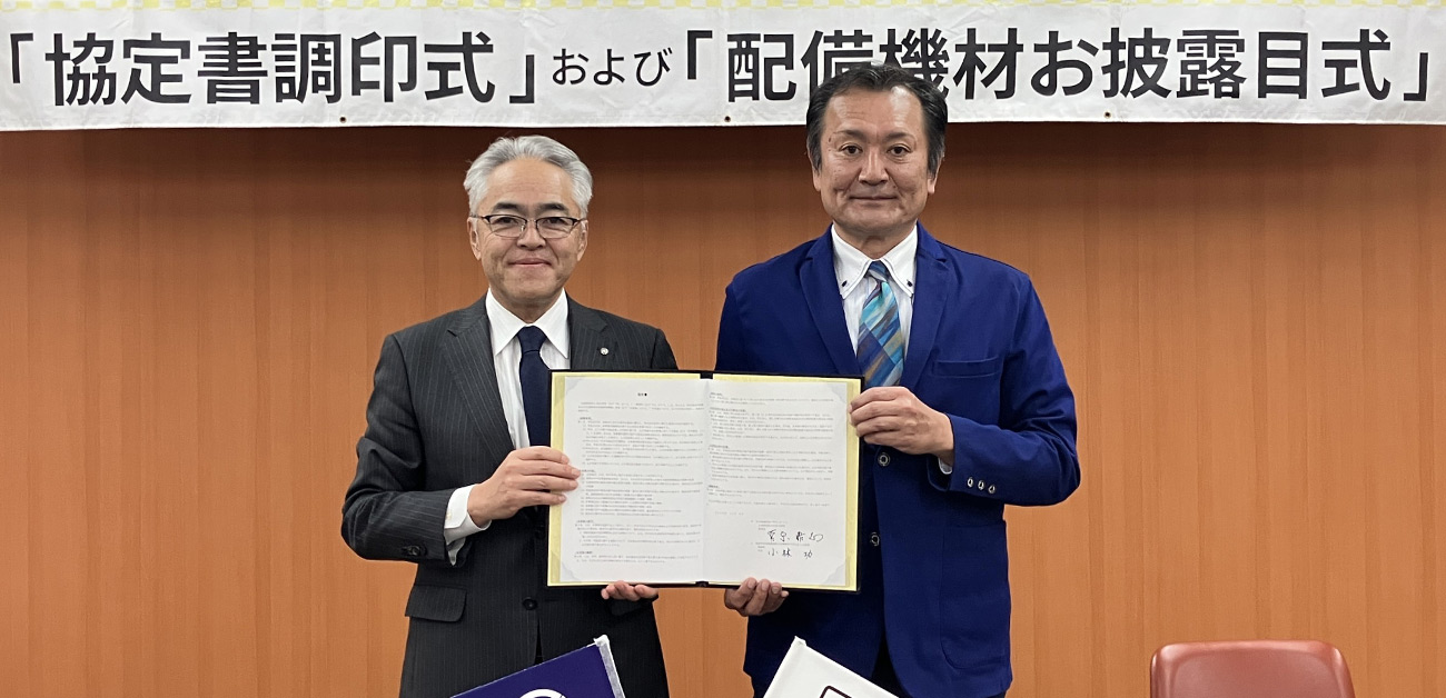 小林町長と菅原理事長の調印の様子