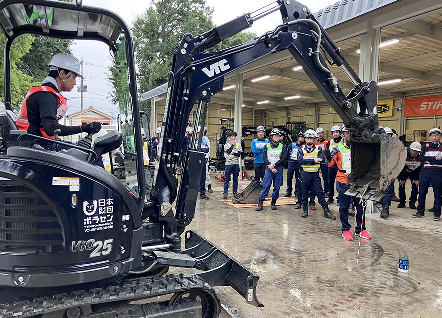 油圧ショベルを操作し、缶に棒を差し込むタイムレース