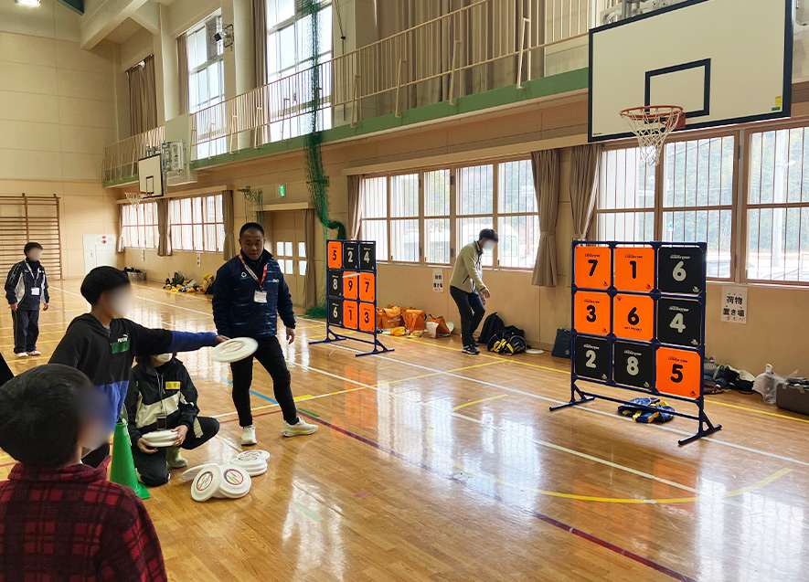  
											的に向かって真剣にディスクを投げる児童たち