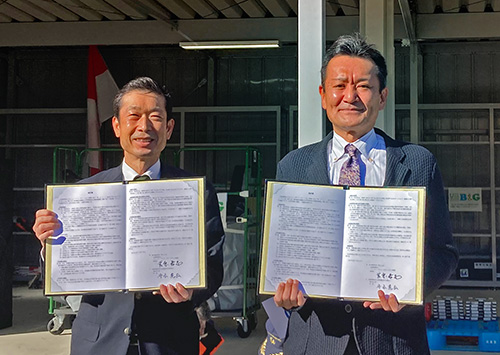 調印書を掲げる守本市長（左）とB&G財団 菅原理事長（右）