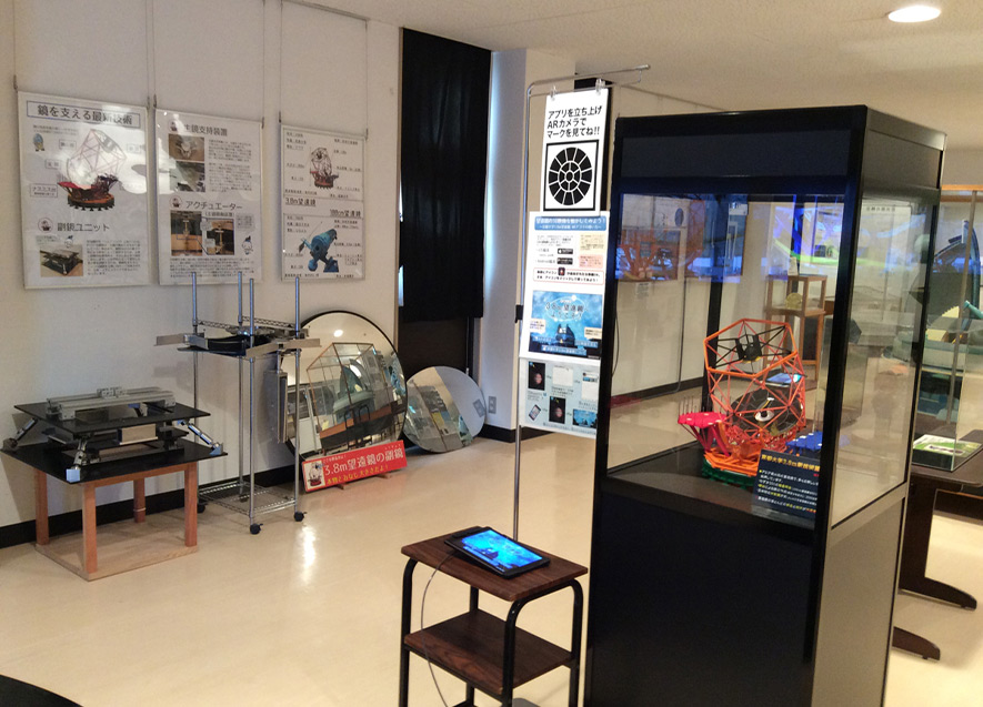 研究成果のパネルと望遠鏡のレプリカなどが展示されている