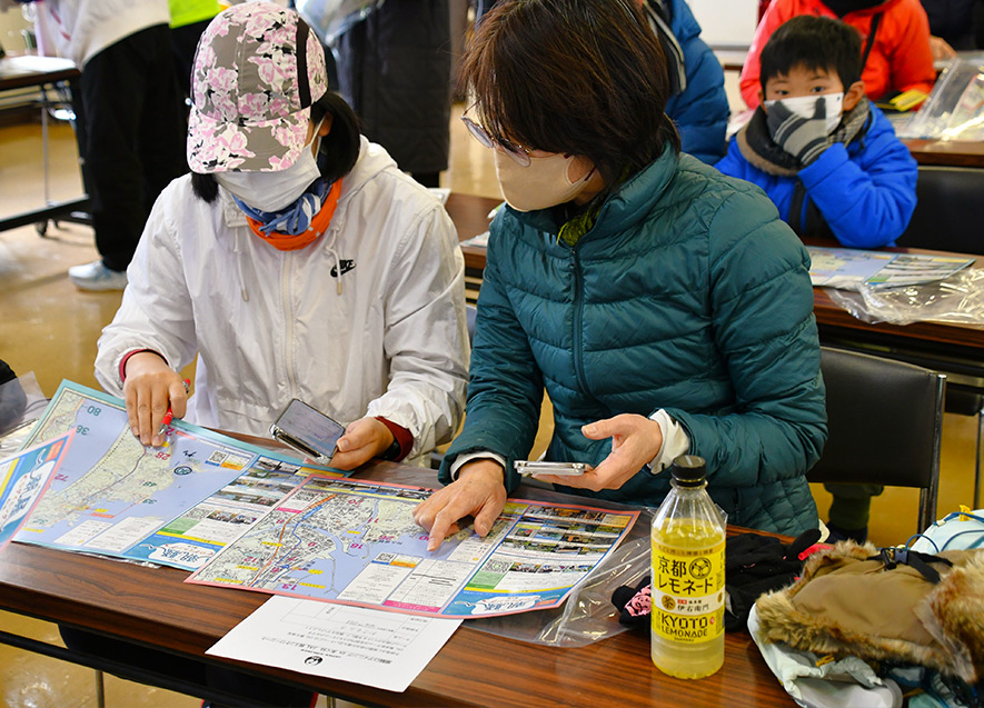 スマートフォンと地図を手に、高得点への道筋を探る作戦タイム